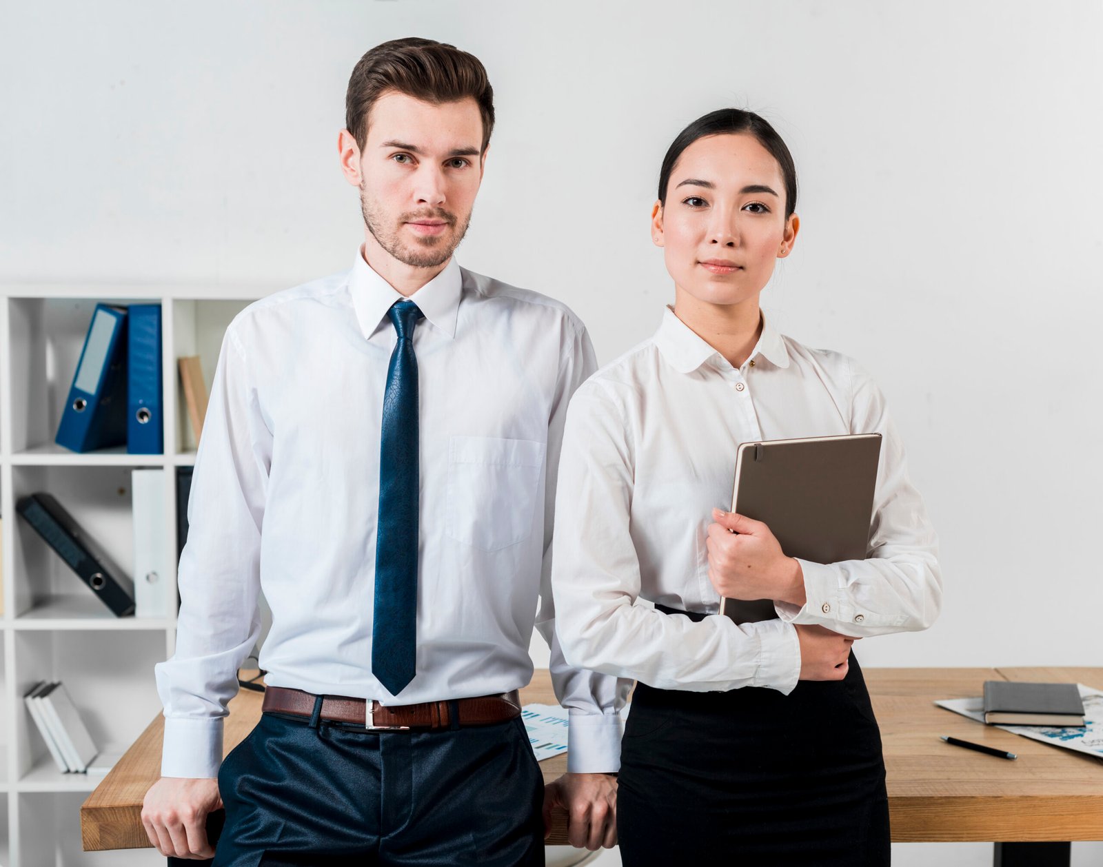 portrait-confident-young-businessman-businesswoman-standing-front-desk